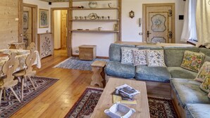 Ein gemütliches Wohnzimmer mit einer Couch, einem Couchtisch und einem Essbereich mit Stühlen und einem Tisch.