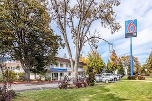 A motel with a '6' sign, a parking lot, and a building with a 'New Hire' sign.
