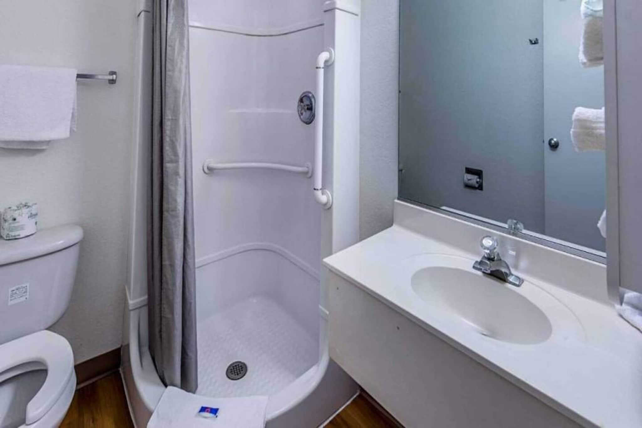 A bathroom with a shower, toilet, and sink.