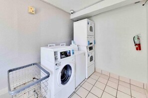 A laundry room with a washing machine, dryer, and a fire extinguisher on the wall. - 2 Full Beds|Motel 6 Austin (Austin)