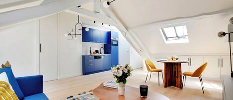 A modern loft apartment with a kitchen, dining area, and living space.