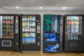 Tre automater med ett varierat utbud av snacks och drycker.