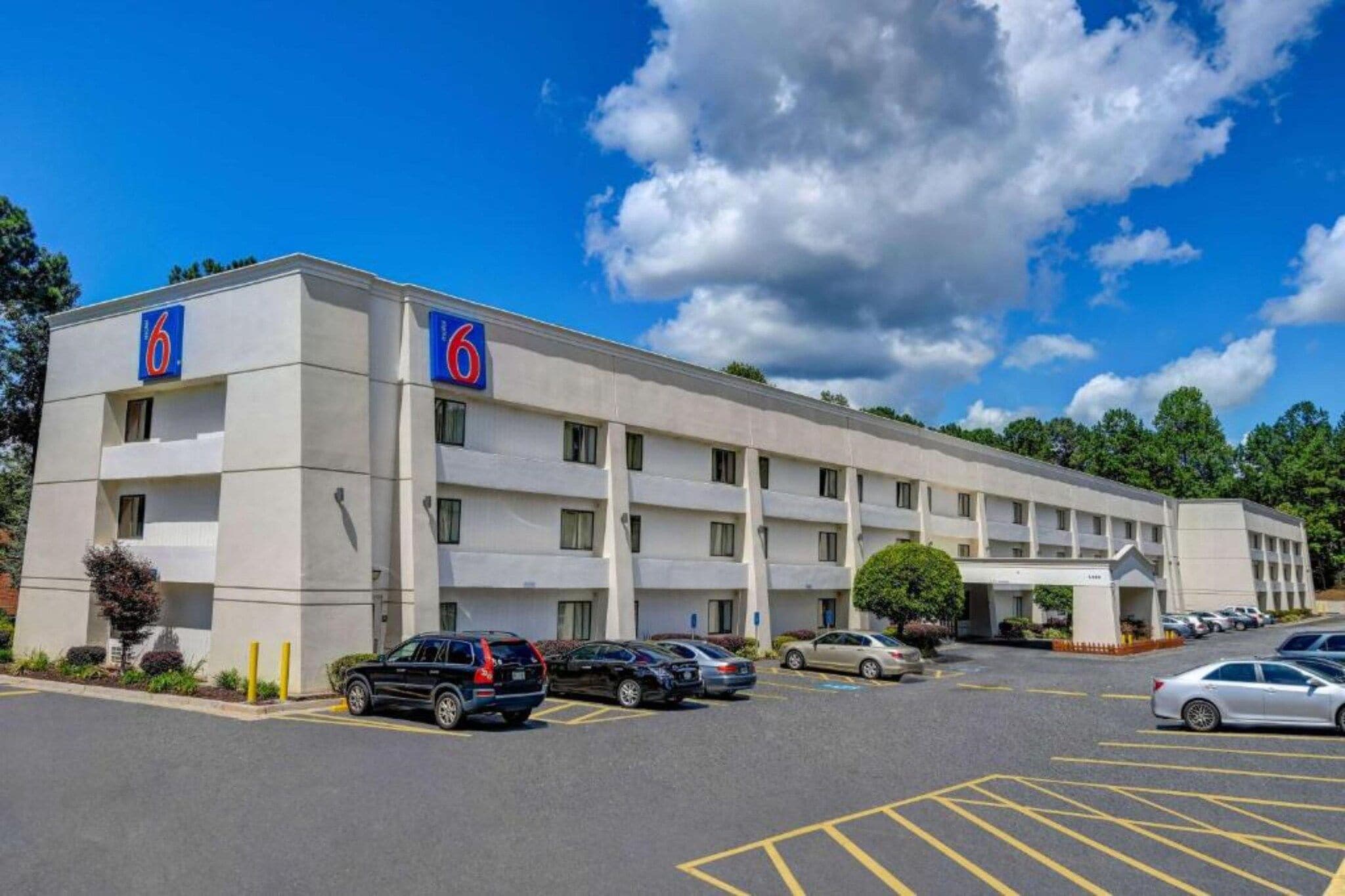 Un hôtel de six étages avec un parking situé à l’avant.