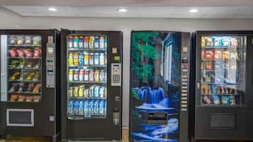Three vending machines with various beverages and snacks.