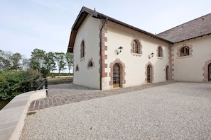 Ein Gebäude mit mehreren Rundbogenfenstern und einem Kieshof.