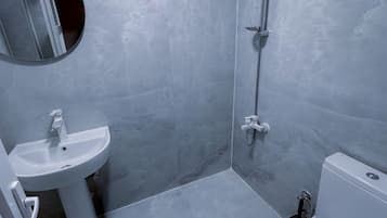 A bathroom with a shower, sink, and toilet.