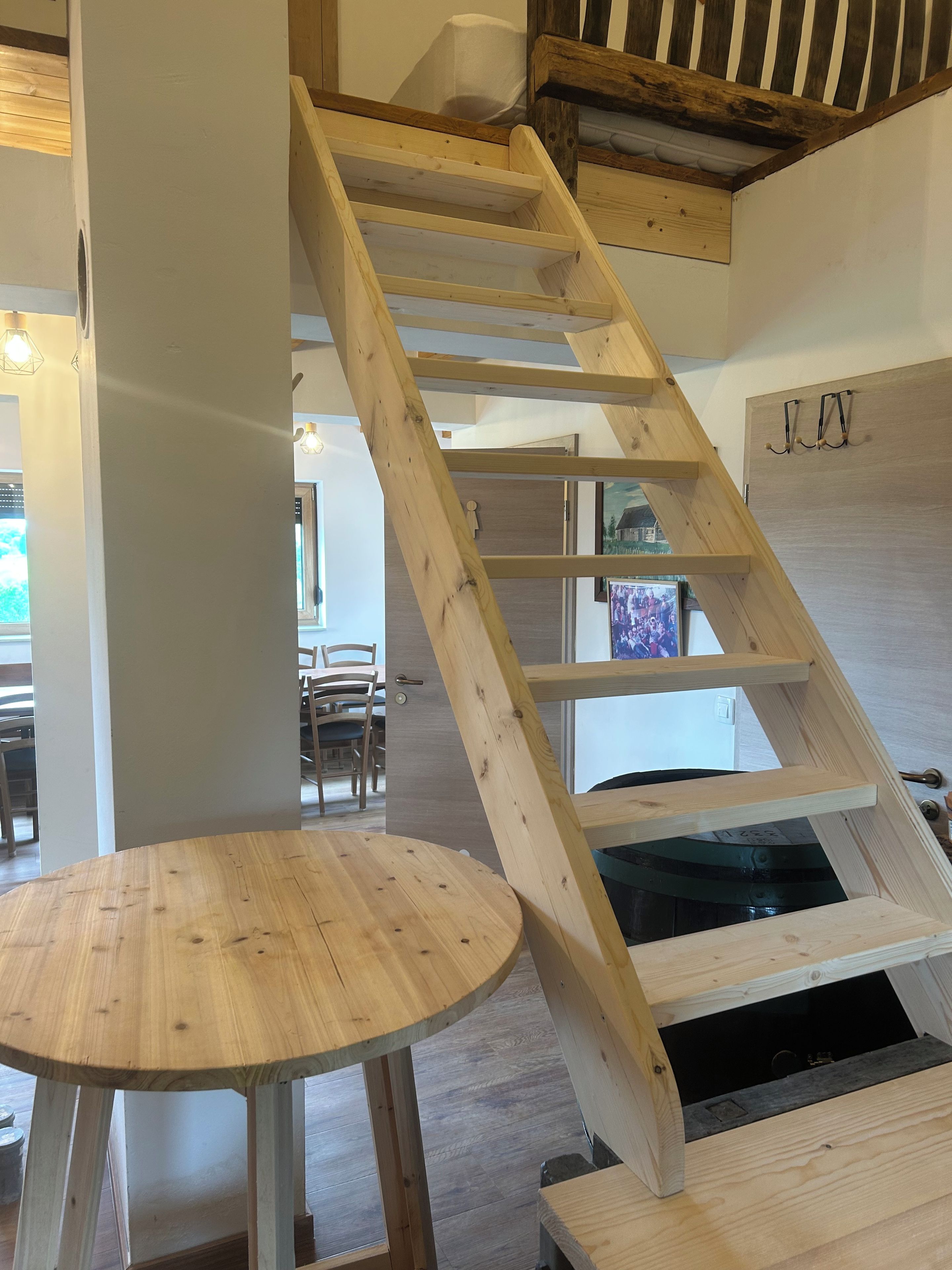 Un escalier en bois offrant une vue sur la salle à manger et la cuisine.