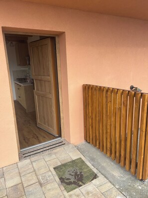 A wooden door leading to a kitchen with cabinets and a countertop. - Cozy 2-bedroom house in charming Gradišča with AC and Sauna (Cirkulane)