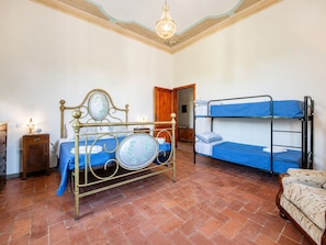 A room with a bed, a bunk bed, a wooden cabinet, a lamp, and a patterned sofa. - B&G Corte Menconi Iris (Orentano)
