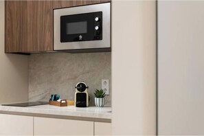 A kitchen with a microwave, a coffee machine, and a potted plant. - "Cobalto" Designer Apartment (Estepona)
