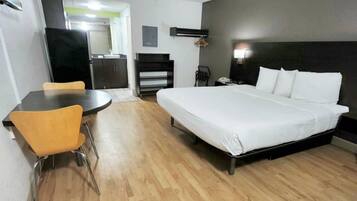 A hotel room with a bed, a desk, and a chair.