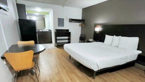 Una habitación de hotel con una cama, un escritorio y una silla.