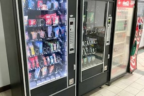 A row of vending machines with various snacks and drinks. - 1 King Bed | Mobil Access Tub Nsmk Kitchen (Columbus GA)