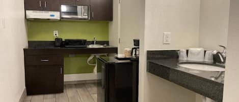 A compact kitchen with a microwave, toaster, and coffee maker.