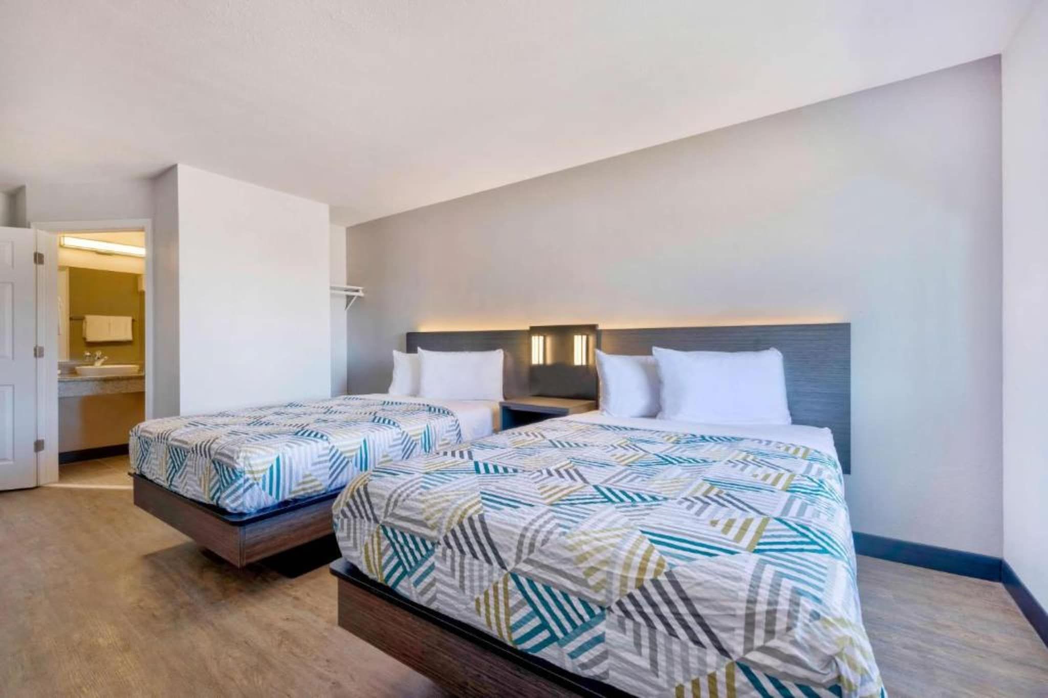 Habitación de hotel con dos camas, un baño y vista al océano.