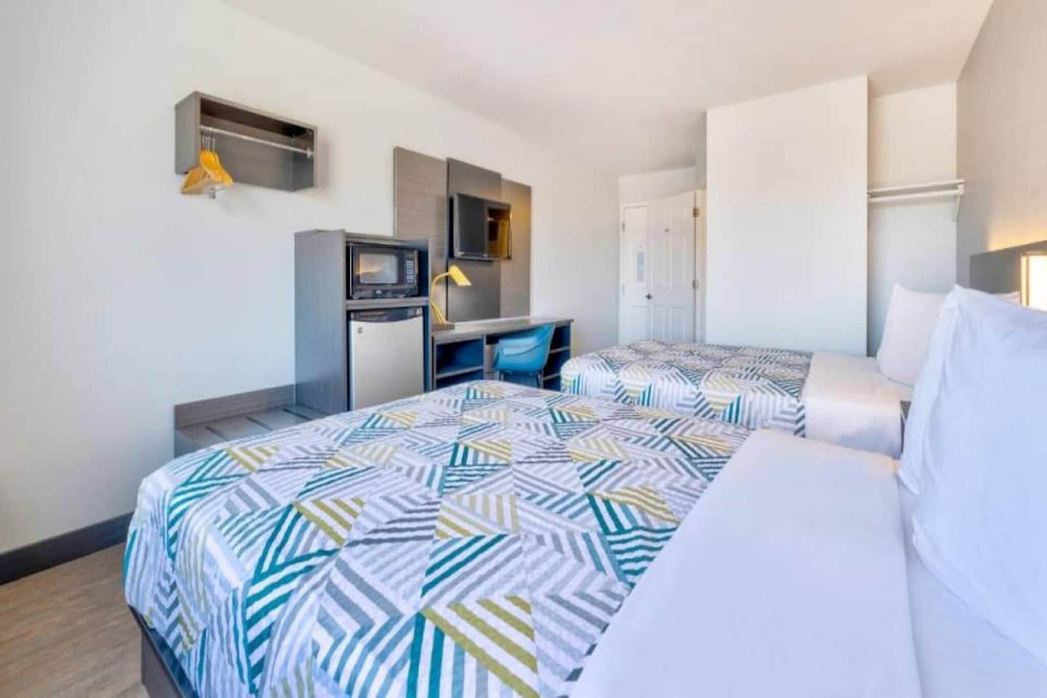 Une chambre d’hôtel équipée d’un lit, d’un bureau, d’un four à micro-ondes et d’une armoire.