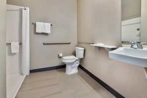 A bathroom with a toilet, a sink, a towel rack, and a shower curtain. - 1 King Bed | Non-Smoking, Micfridge (Norman)
