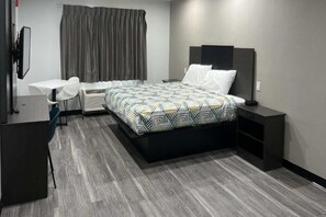 Een moderne hotelkamer met een bed, nachtkastjes, een bureau en een stoel.
