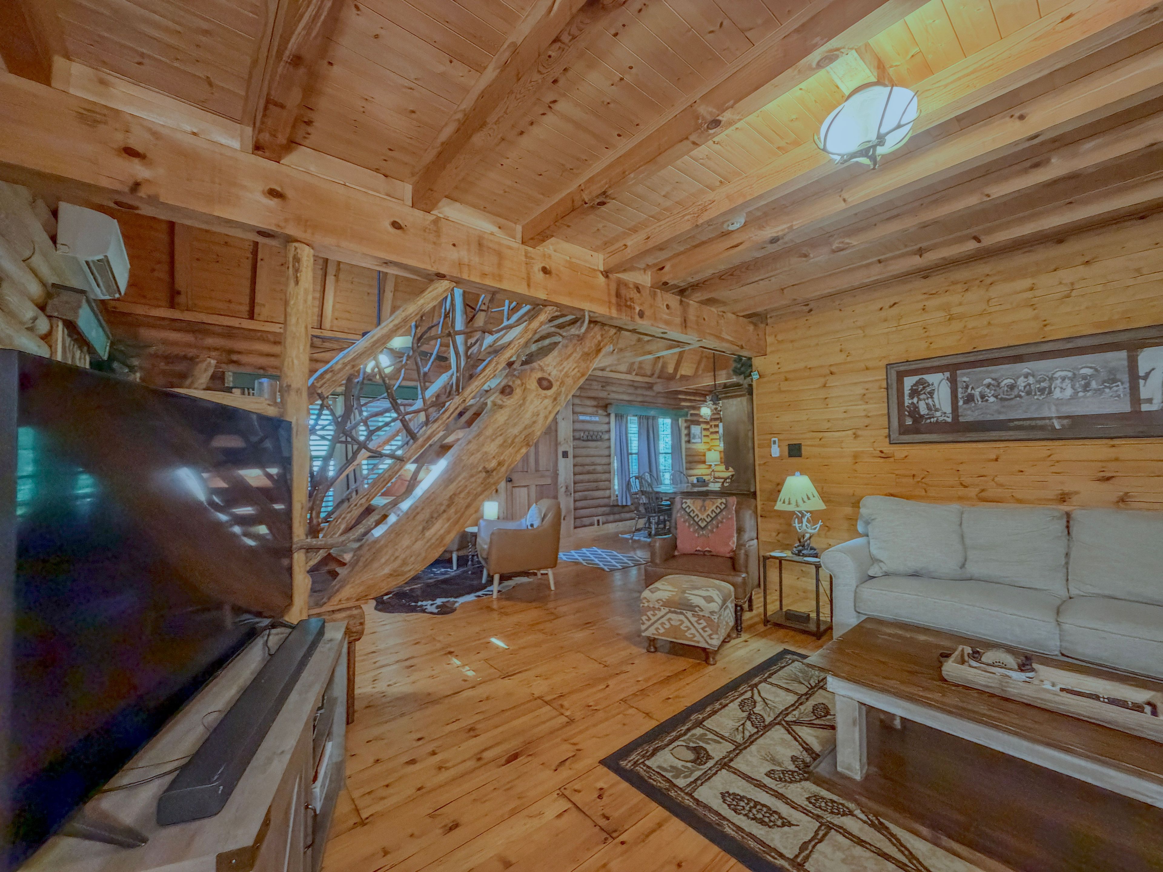 Un interior de madera con una escalera, un televisor, un sofá y una lámpara.