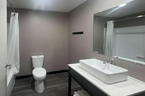 Une salle de bain avec des toilettes, un lavabo et un miroir.