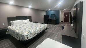Ein modernes Hotelzimmer mit einem großen Bett, einem Schreibtisch, einem Stuhl und einem Kleiderschrank.