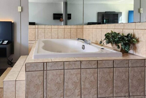 Een moderne badkamer met een groot bad, een wastafel en een spiegel.