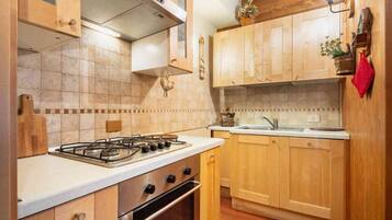 Una cucina con mobili in legno, un fornello a gas e un lavello.