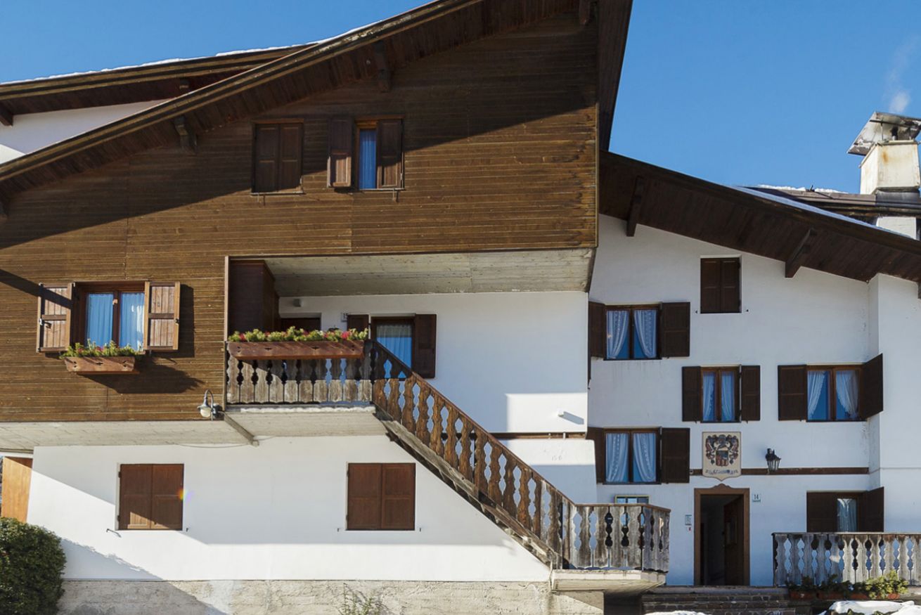 Un edificio de dos pisos con balcones de madera y una escalera.