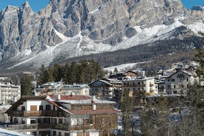 Un paese montano con cime innevate sullo sfondo e edifici residenziali in primo piano.