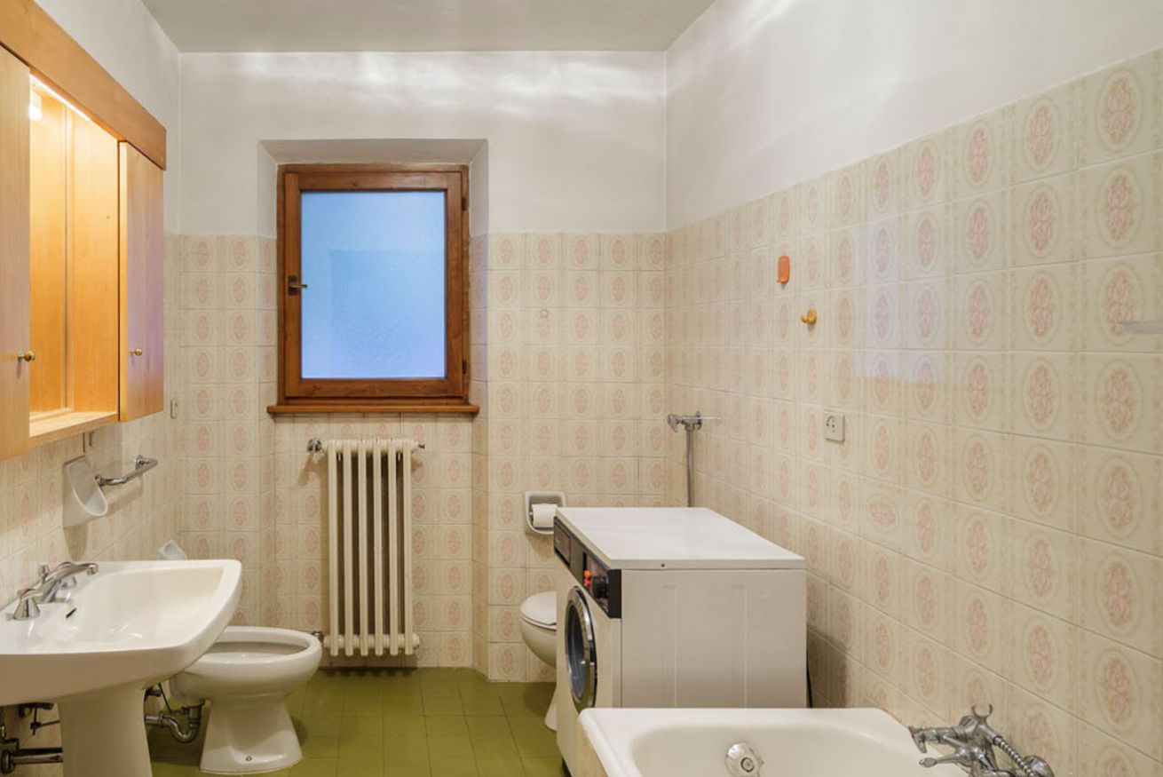 A bathroom with a sink, toilet, washing machine, and bathtub.