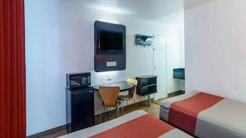 Habitación de hotel con dos camas, un escritorio, una silla, un televisor y un minibar.