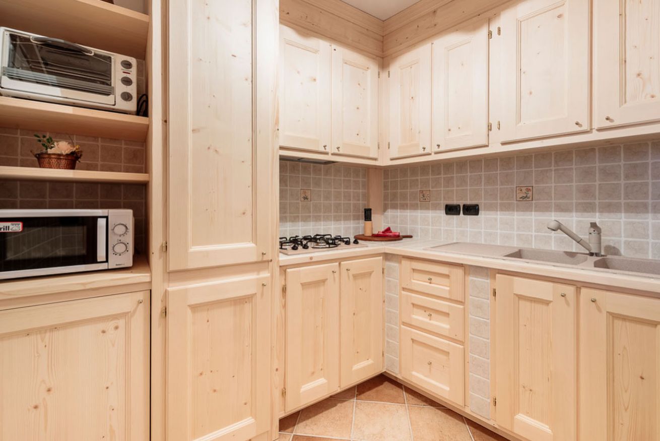 A kitchen with wooden cabinets, a microwave, a stove, and a sink.