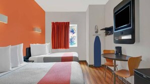 A hotel room with two beds, a desk, a chair, a television, and a window with curtains. - 2 Full Beds | Premium, Mini Fridge (Orlando FL)
