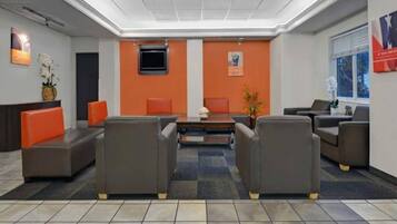 A lobby with a reception desk, seating area, and a large window.