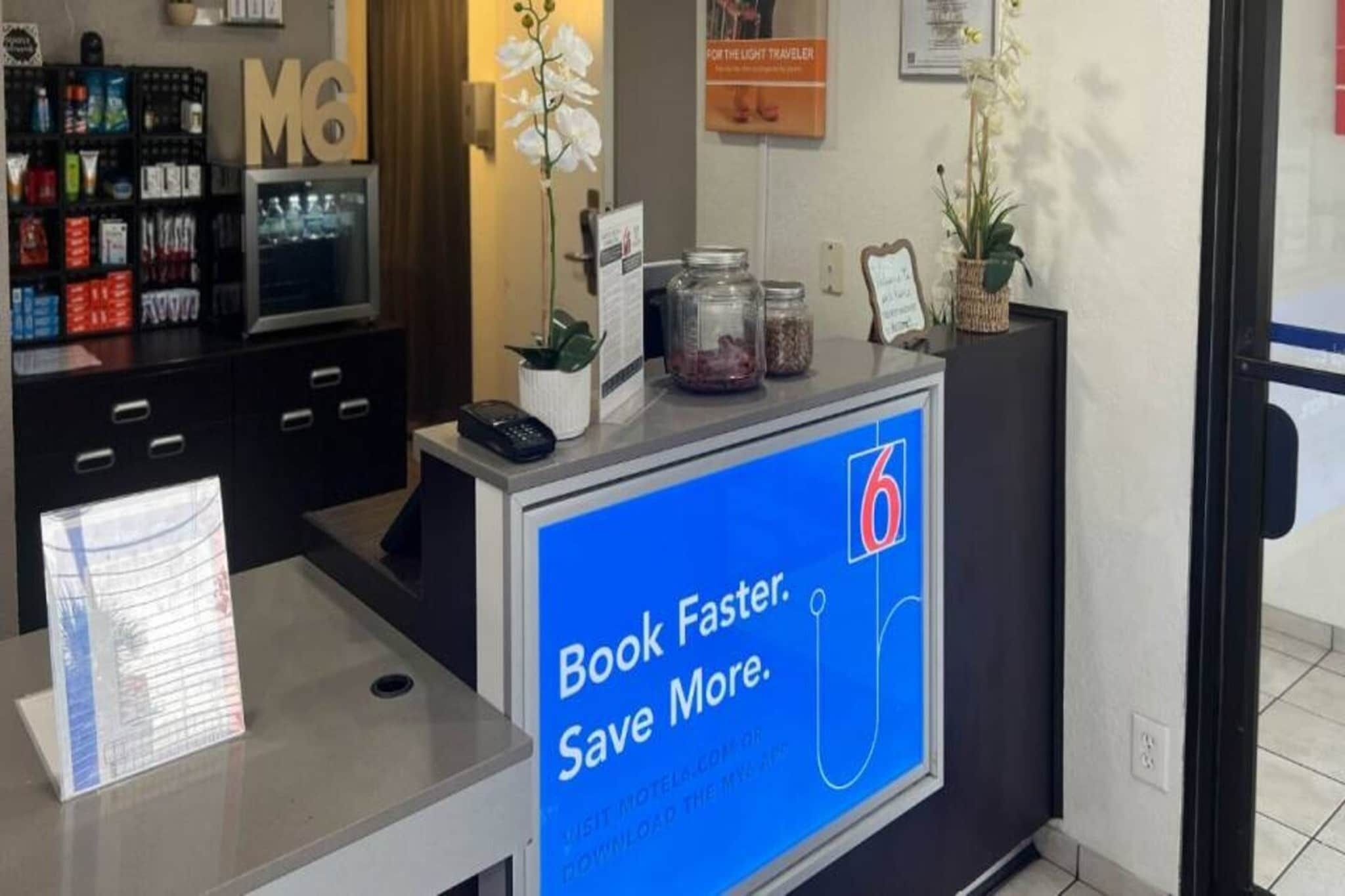 Un comptoir d’accueil d’hôtel doté d’un écran numérique affichant un message promotionnel.