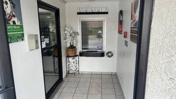 Un couloir avec une pancarte « Bienvenue », une fenêtre avec des stores, une porte et une pancarte « ESPACE DÉTENTE ».