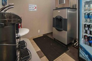 A kitchenette with a sink, stove, and water dispenser. - Motel 6 Ft. Pierce, Fl | 1 Queen Bed (Fort Pierce)