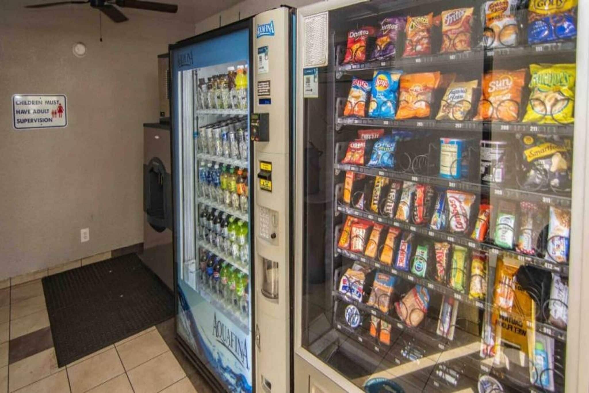 Área com máquina de vendas automática, bebedouro e máquinas de venda de lanches.