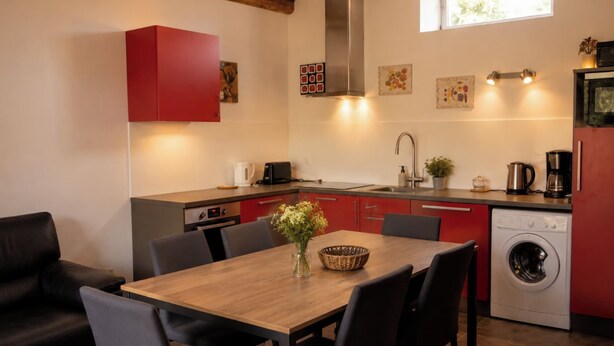 A compact kitchen with a dining area, a washing machine, and a red cabinet. - A gorgeous, cozy vacation rental, perfect for families, with a garden, near Disney and Paris. The workshop. (Aulnoy)