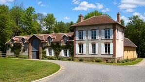 A large, multi-story house with a driveway and a well-maintained lawn. - A gorgeous, cozy vacation rental, perfect for families, with a garden, near Disney and Paris. The workshop. (Aulnoy)