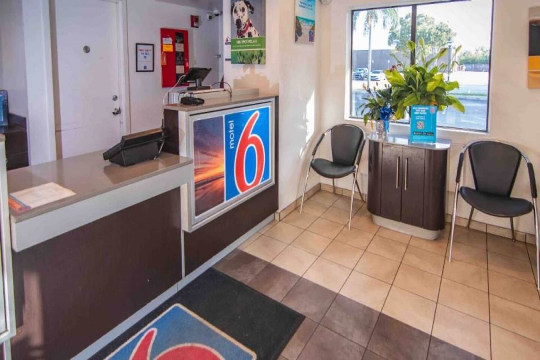 A reception area with a desk, chairs, a large window, and a sign indicating the number 6.