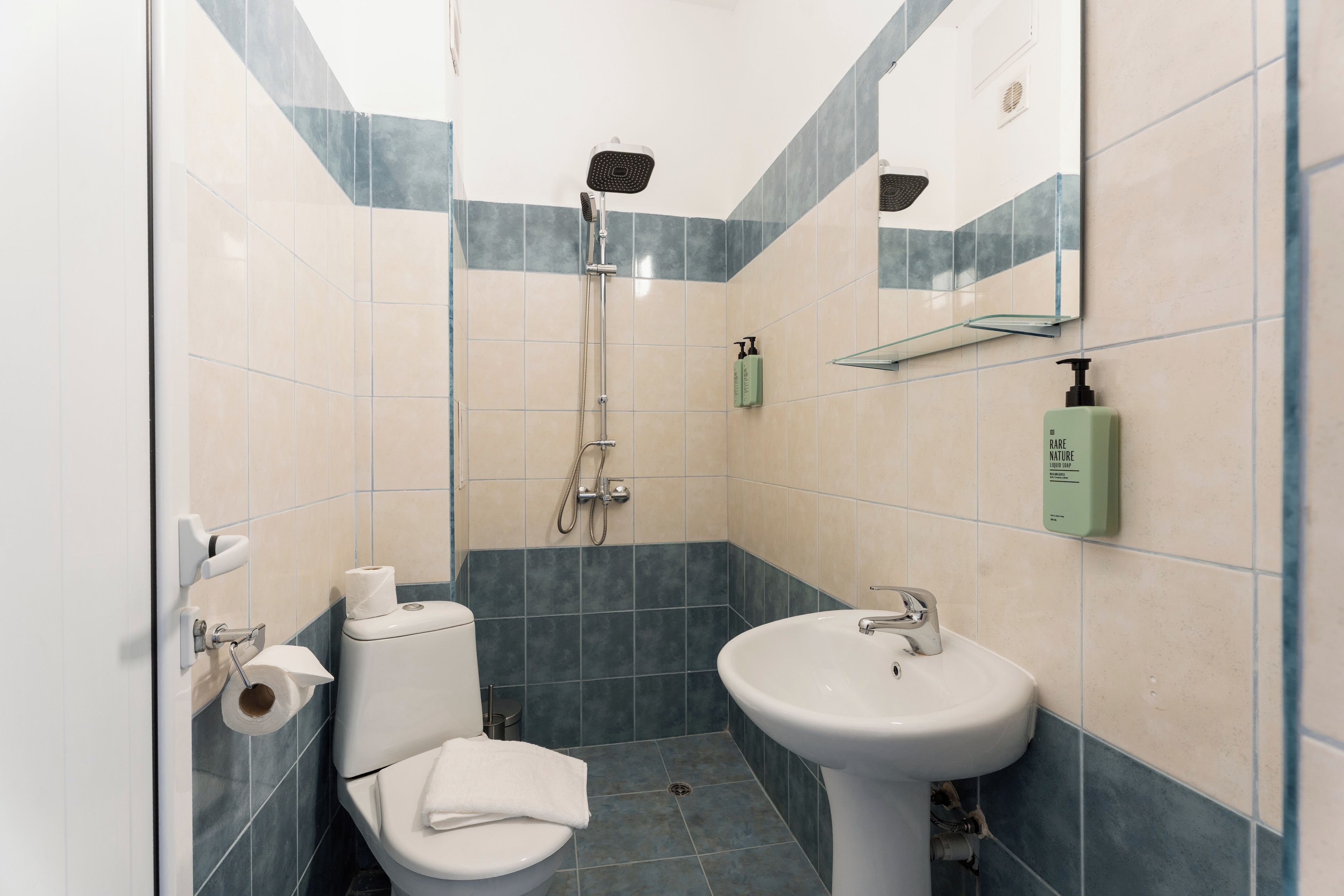 A bathroom with a toilet, sink, and shower.