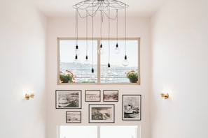 A room with a large window, multiple light bulbs, and framed photographs on the wall. - Hotel Sozopol 99 (Sozopol)
