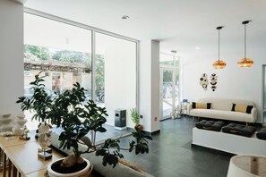 Un interior moderno con un sofá, una mesa de comedor y una planta en maceta.