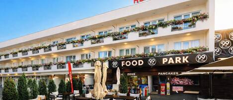 A hotel with outdoor seating and a food park.