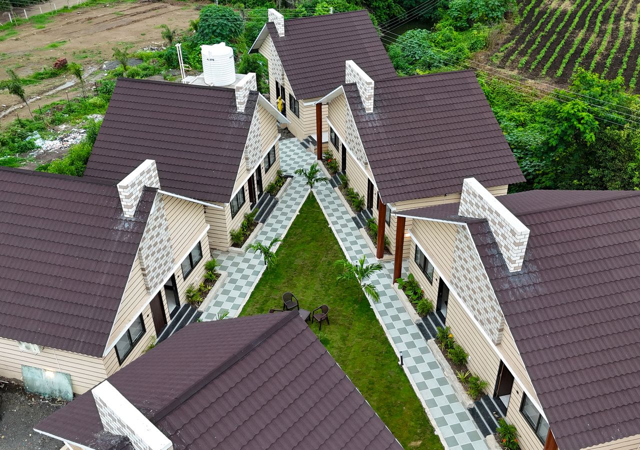A residential building with multiple units, each featuring a dark roof and a small front yard.