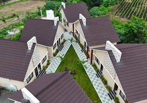 A residential building with multiple units, each featuring a dark roof and a small front yard. - Hotel Atithi Resort (Khuldabad)