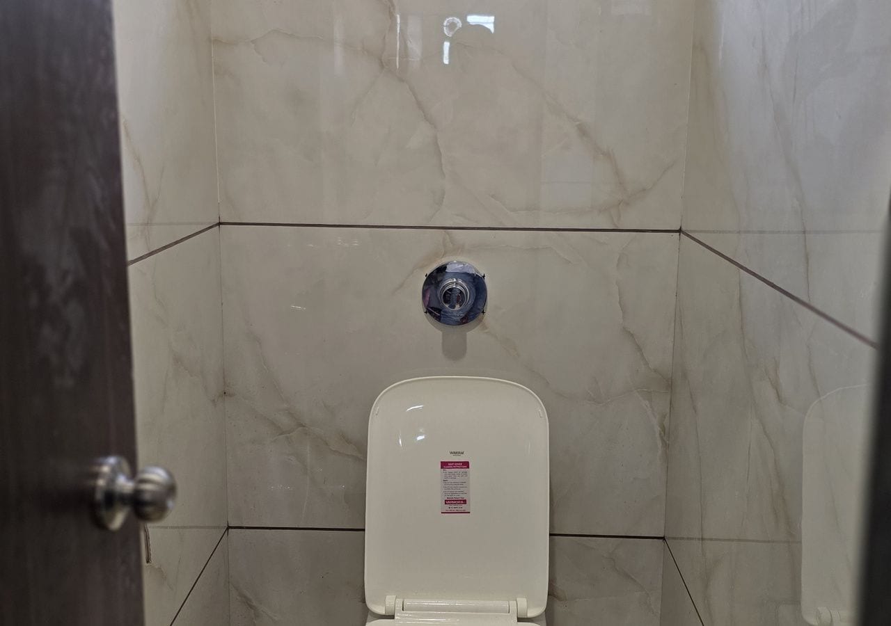 Un baño con inodoro, ducha y puerta.