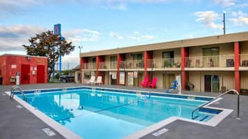 A motel with a swimming pool, a red brick building, and a two-story structure with balconies.