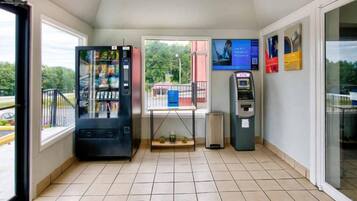 Et værelse med en automat, en pengeautomat og et vindue med udsigt.